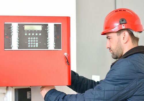 a man wearing a safety helmet inspecting a fire system